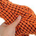 Load image into Gallery viewer, Orange textured dog toy held by a hand on a white background