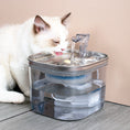 Load image into Gallery viewer, Cat drinking water from a clear pet fountain on a wooden floor.
