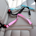 Load image into Gallery viewer, Two dog leashes, one pink and one black with red accents, on a car seat.
