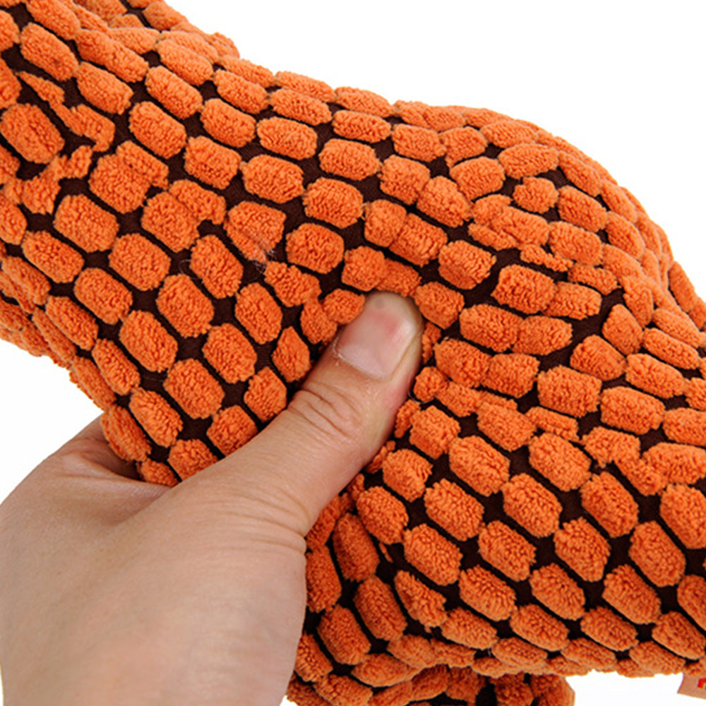 Orange textured dog toy held by a hand on a white background