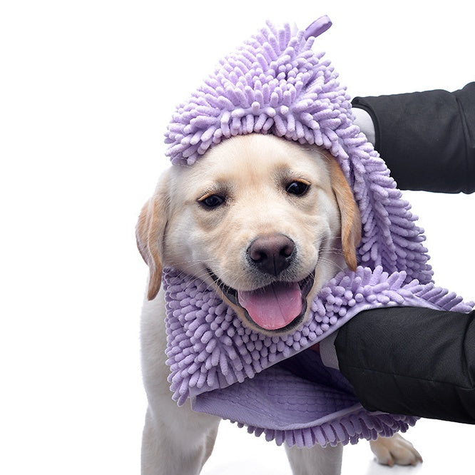 Dog wrapped in a purple towel with a white background
